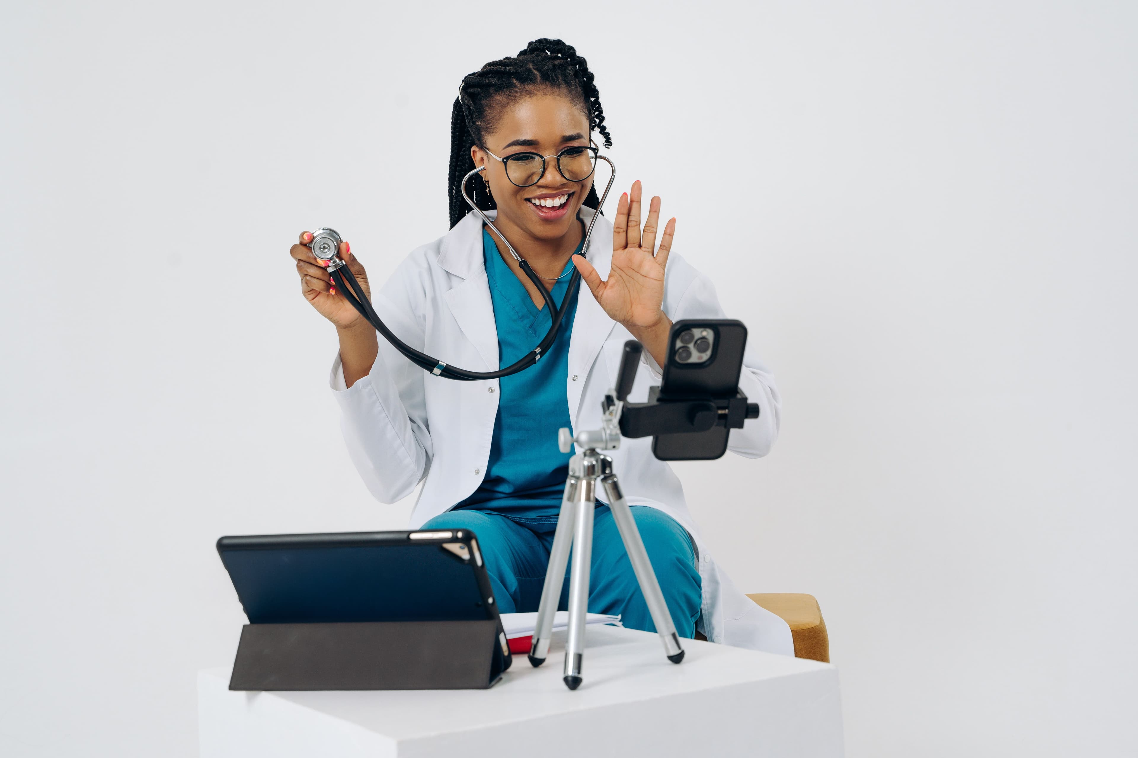 A doctor smiling while starting a video consultation